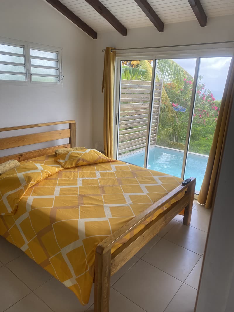 Le lit double face à la baie vitrée donnant sur la piscine