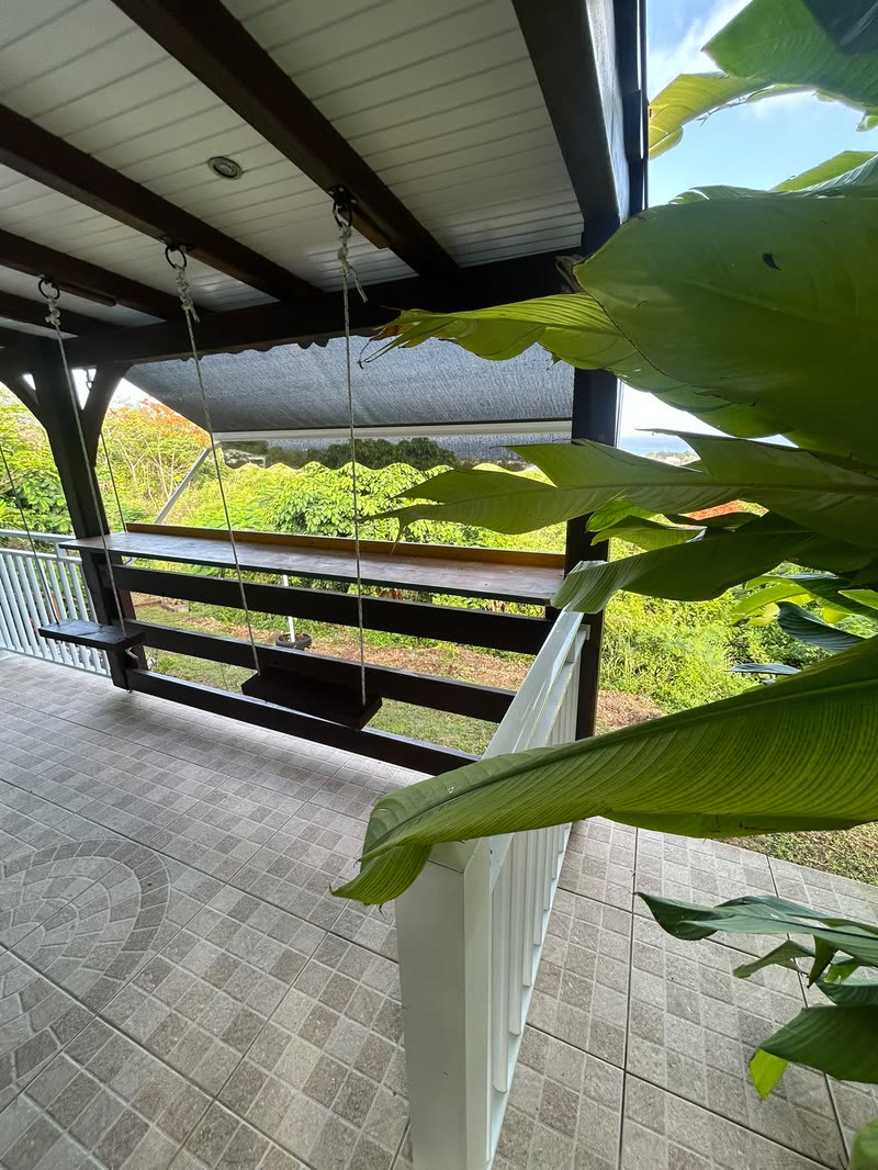 La terrasse couverte et sa balancelle, face à la vallée